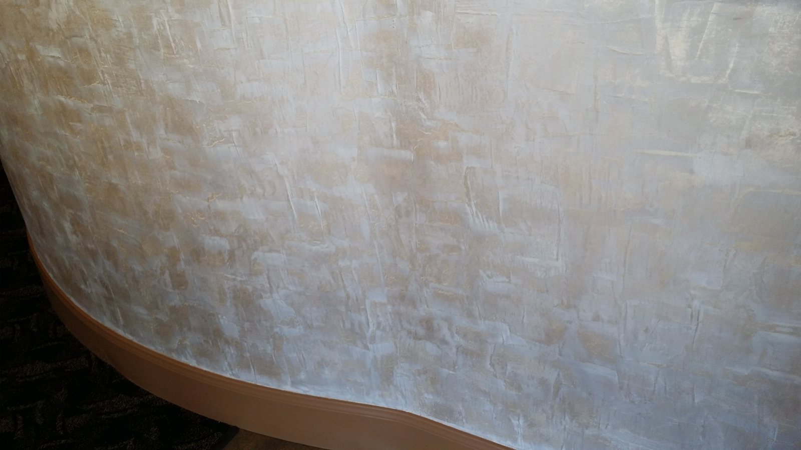 Close view of layered Venetian plaster on a curved wall
